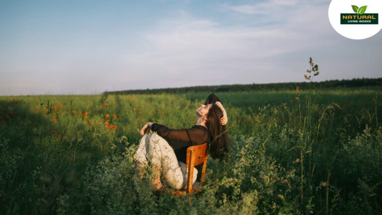 A woman enjoys a serene moment sitting among vibrant flowers in a peaceful field, embodying the essence of slow living.