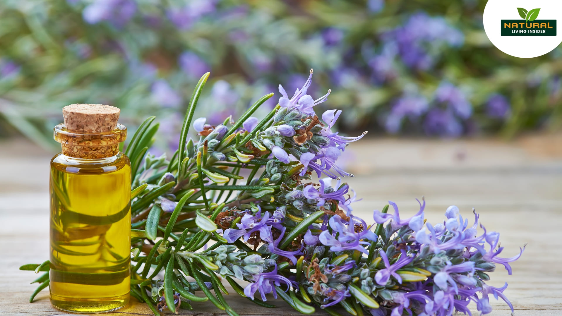 A small bottle of rosemary essential oil surrounded by fresh rosemary sprigs on a wooden surface.