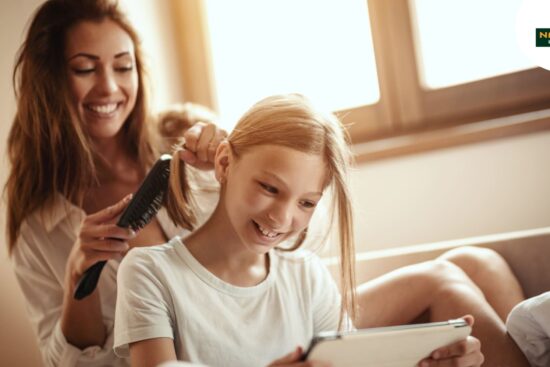 Woman and child explore chemical-free hair care on a tablet.