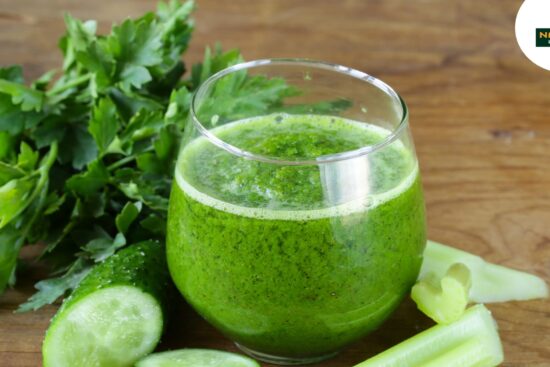 A vibrant green juice of celery on a wooden table, representing a healthy detox drink for wellness enthusiasts.