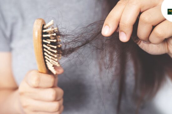 A woman is seen using a comb to brush her thinning hair, highlighting a serene moment of daily beauty routine.