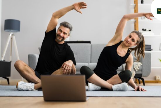 A man and woman practicing exercise together via a laptop, showcasing fitness tips and wellness insights.