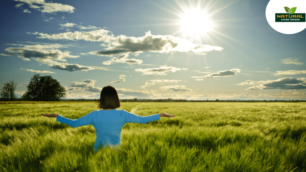 A woman in a field, arms wide, embracing natural harmony and health.